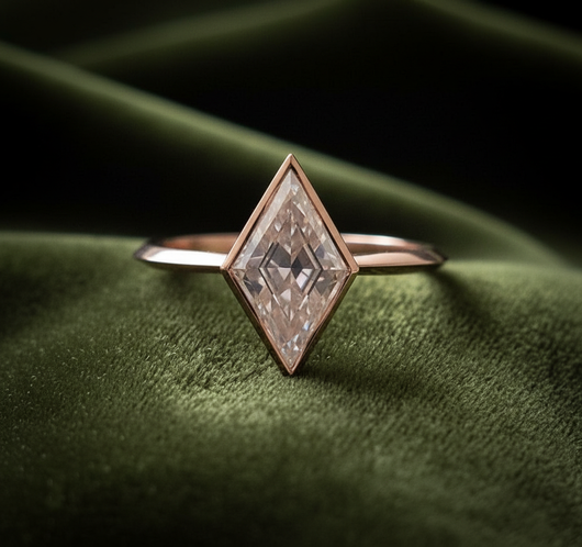 Kite-shaped diamond ring on dark olive green velvet